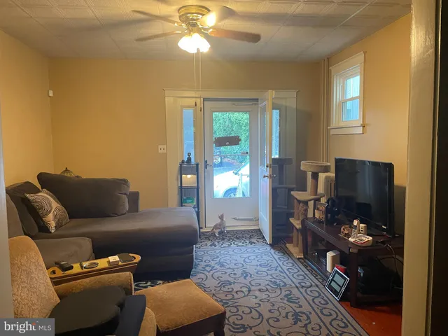 a living room with furniture a window and a flat screen tv