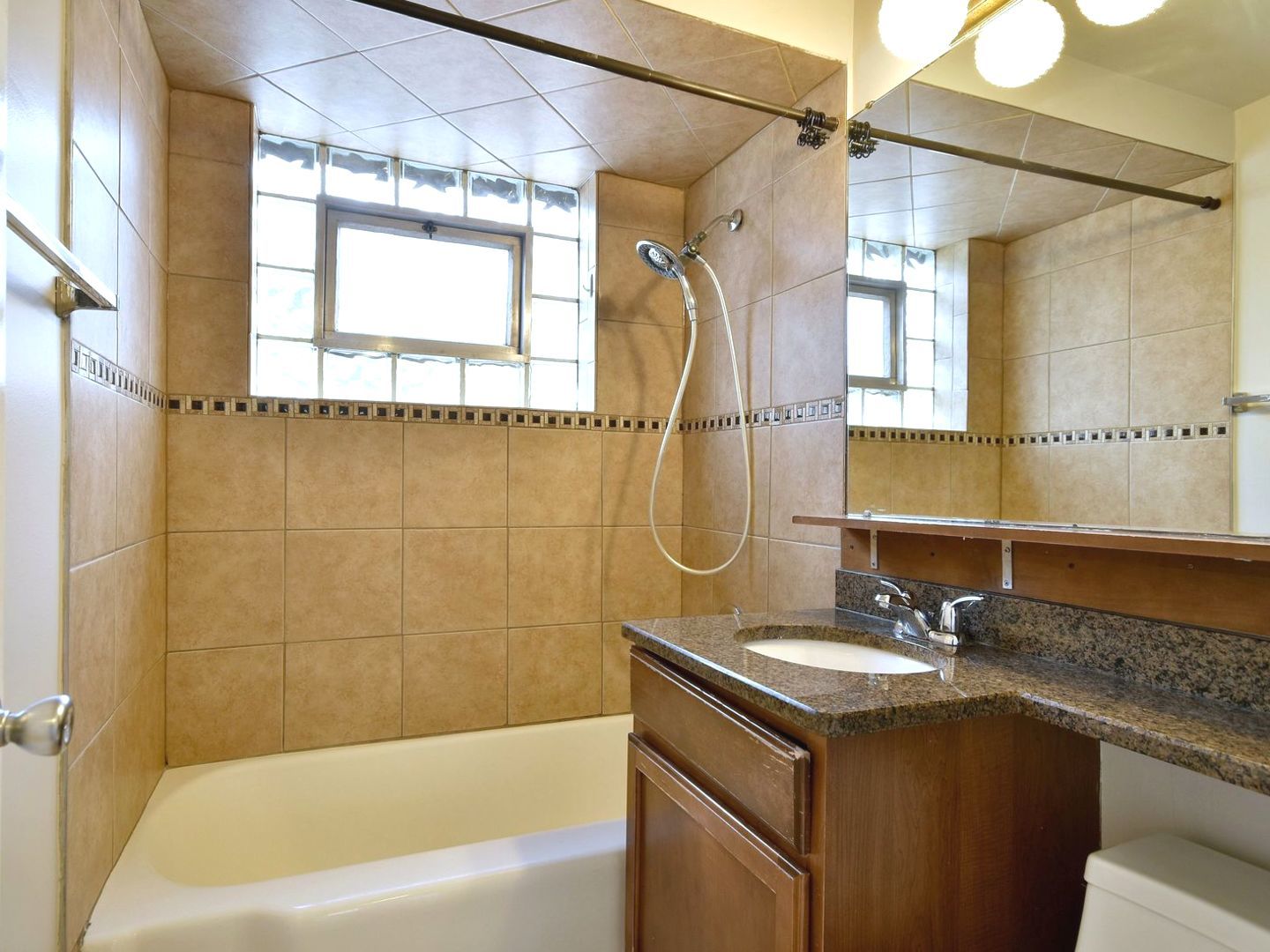5220 South Rutherford Avenue Chicago, IL 60638 - Photo 13 of 18 a bathroom with a granite countertop sink a mirror a bathtub and shower
