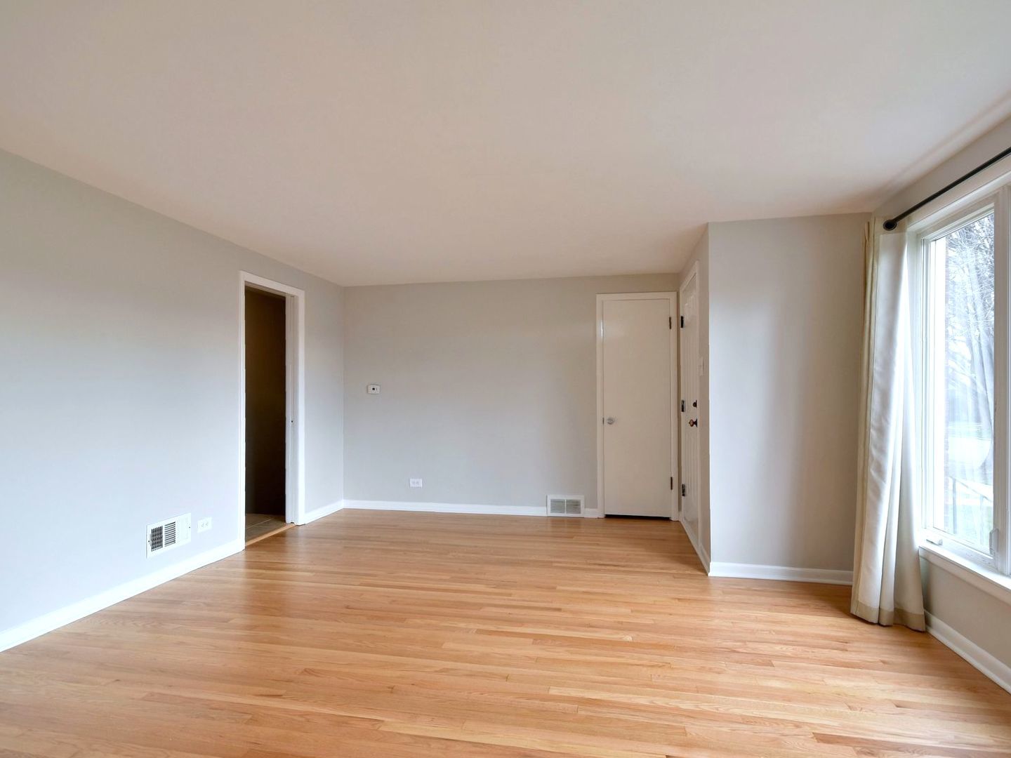 5220 South Rutherford Avenue Chicago, IL 60638 - Photo 5 of 18 a view of an empty room with wooden floor and windows