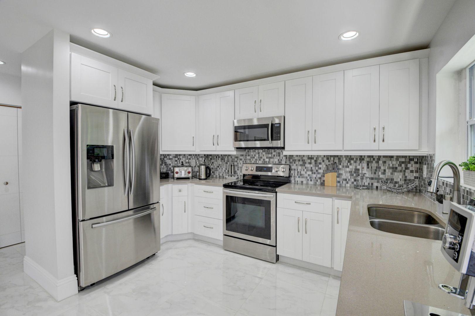2157 Northwest 52nd Street Boca Raton, FL 33496 - Photo 13 of 27 a kitchen with cabinets stainless steel appliances and a sink