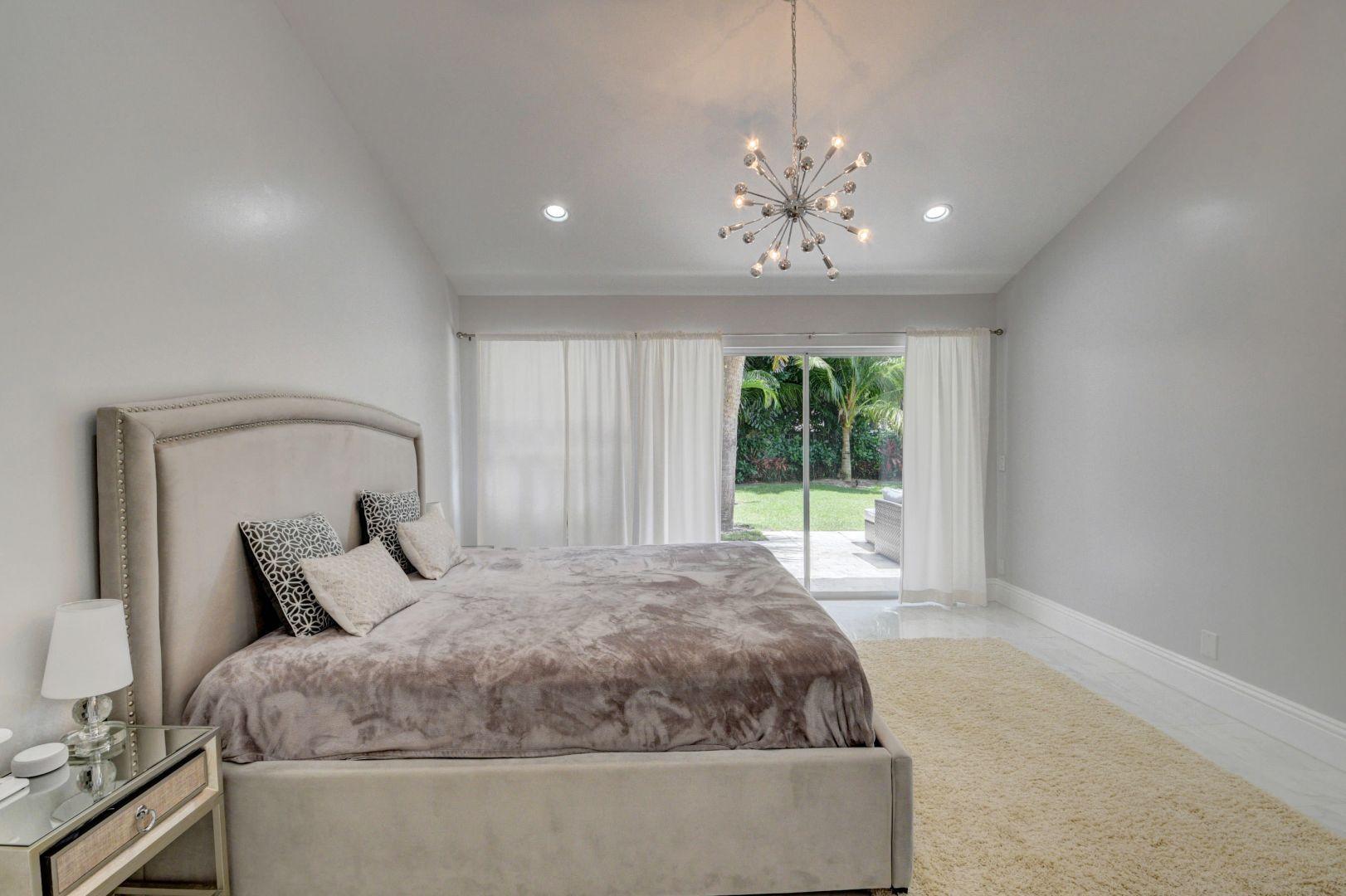 2157 Northwest 52nd Street Boca Raton, FL 33496 - Photo 16 of 27 a large bed sitting in a room next to a window