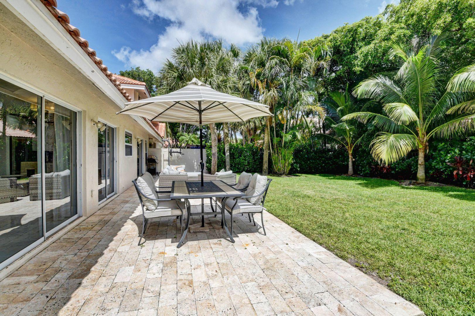 2157 Northwest 52nd Street Boca Raton, FL 33496 - Photo 27 of 27 a view of a patio with a table and chairs under an umbrella