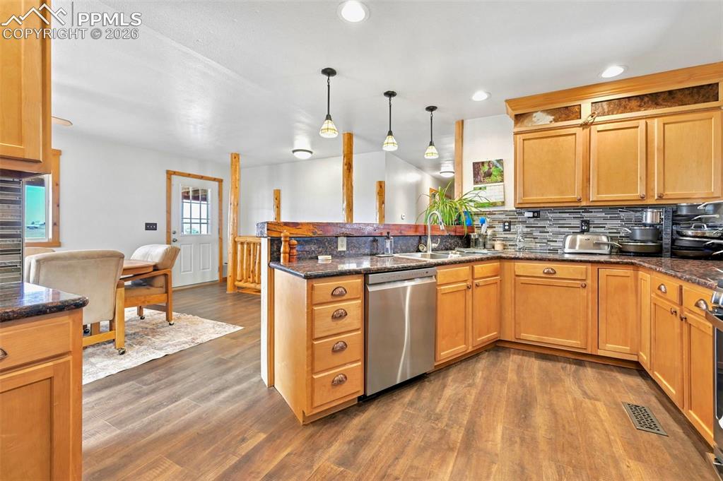 18560 Chelton Road Ramah, CO 80832 - Photo 6 of 34 a open kitchen with stainless steel appliances granite countertop wooden floors wooden cabinets a sink and a window