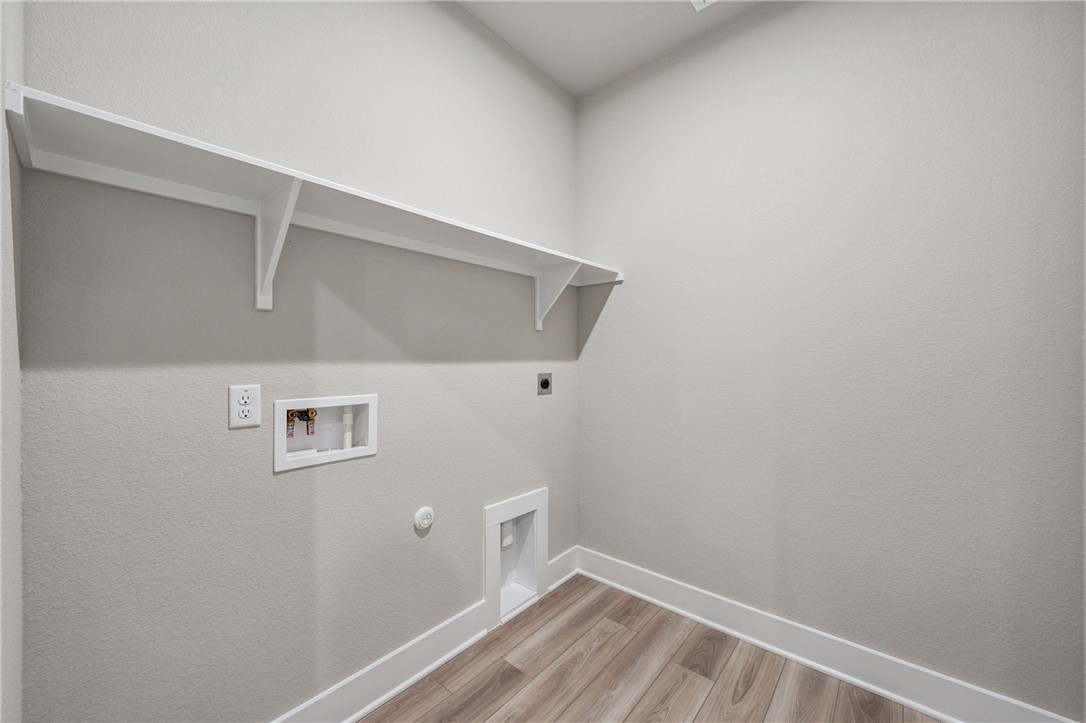 6408 Raleigh Loop College Station, TX 77845 - Photo 9 of 12 Laundry room featuring hookup for a gas dryer, light wood finished floors, washer hookup, and electric dryer hookup