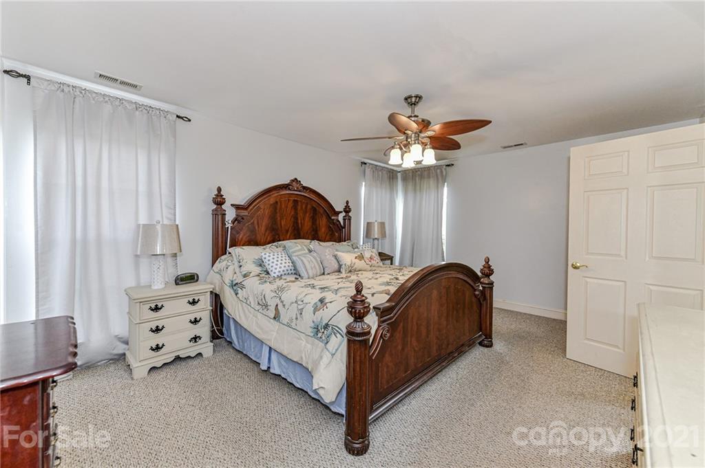 350 Curlee Road Polkton, NC 28135 - Photo 16 of 44 a spacious bedroom with a bed and a chandelier