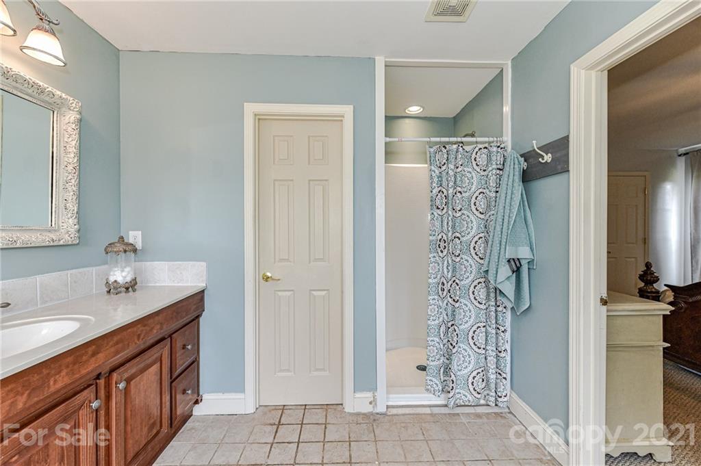 350 Curlee Road Polkton, NC 28135 - Photo 20 of 44 a bathroom with a granite countertop shower sink and a mirror