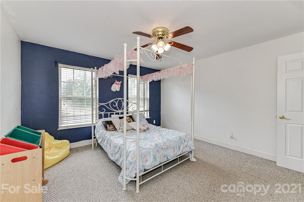 350 Curlee Road Polkton, NC 28135 - Photo 30 of 44 a bedroom with a bed chandelier and a window