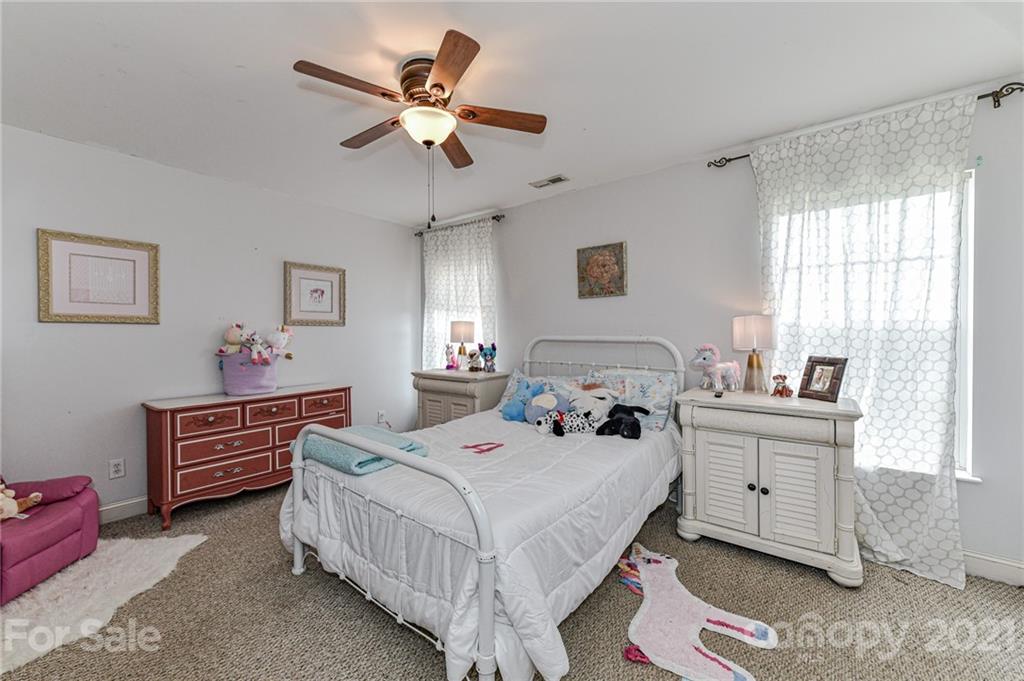 350 Curlee Road Polkton, NC 28135 - Photo 33 of 44 a bedroom with a bed chandelier and a window