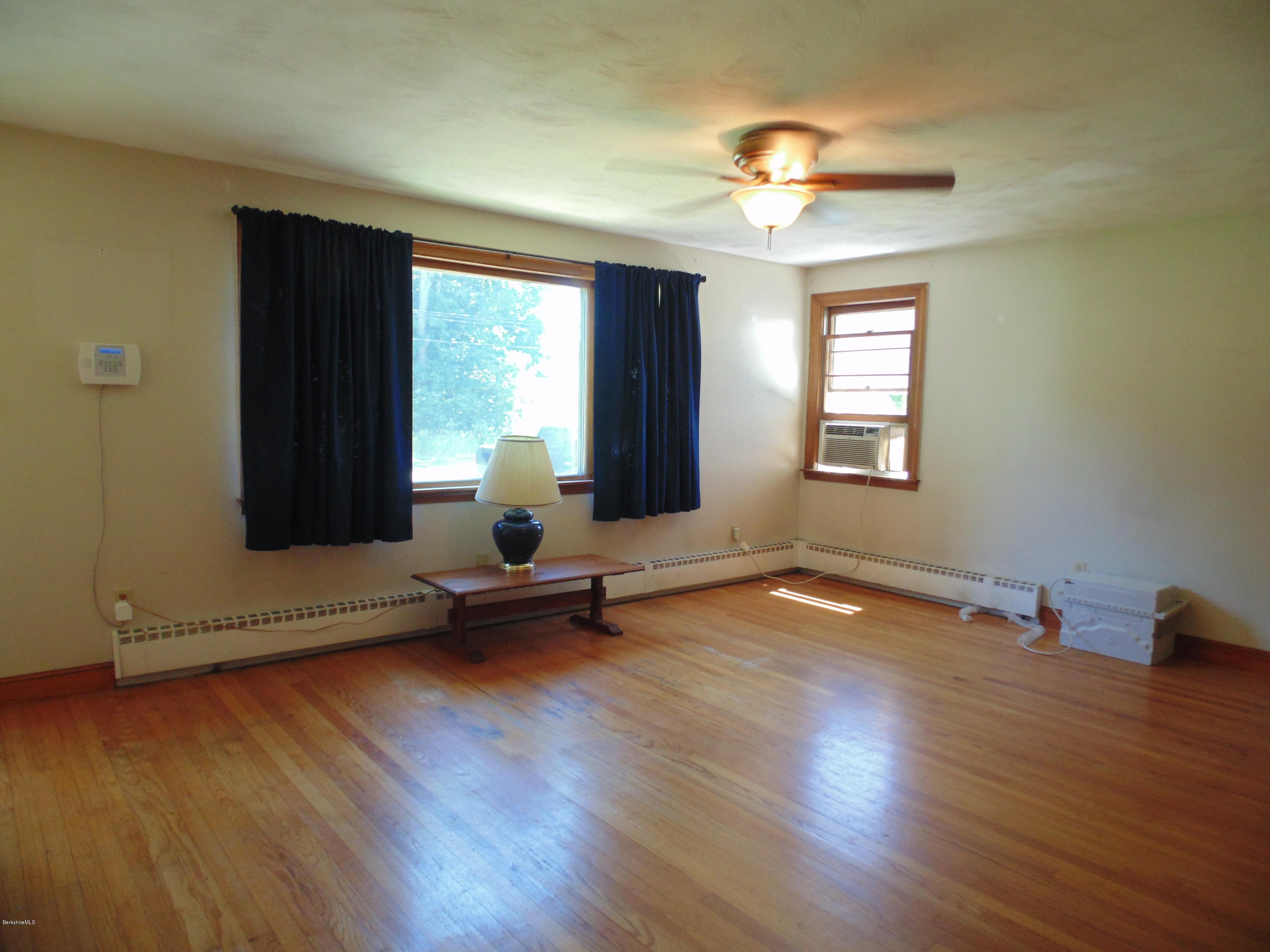 390 Montgomery Road Westfield, MA 01085 - Photo 9 of 29 a view of an empty room with a window and wooden floor