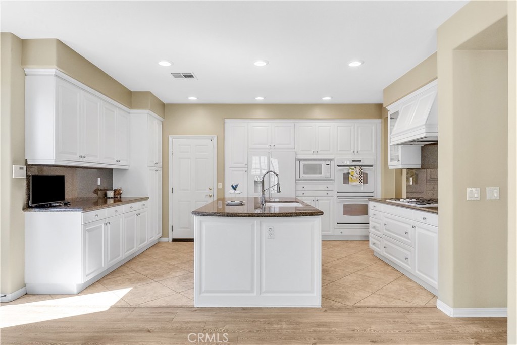 2094 Ward Street Fullerton, CA 92833 - Photo 22 of 66 a kitchen with white cabinets appliances and sink