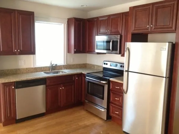 a kitchen with granite countertop a refrigerator stove and microwave