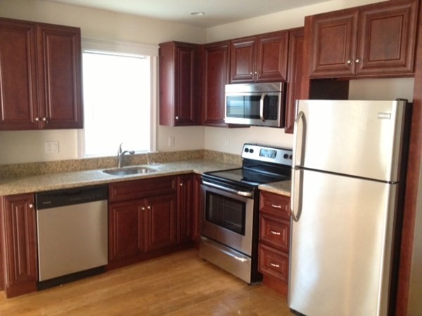200 Brooks Street, Unit 1 Boston, MA 02128 - Photo 1 of 10 a kitchen with granite countertop a refrigerator stove and microwave