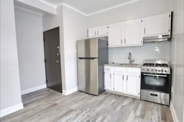 a kitchen with a white cabinets and wooden floor