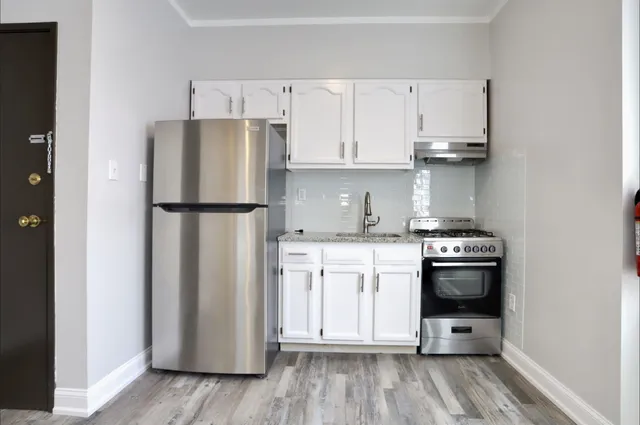 a kitchen with white cabinets and stainless steel appliances