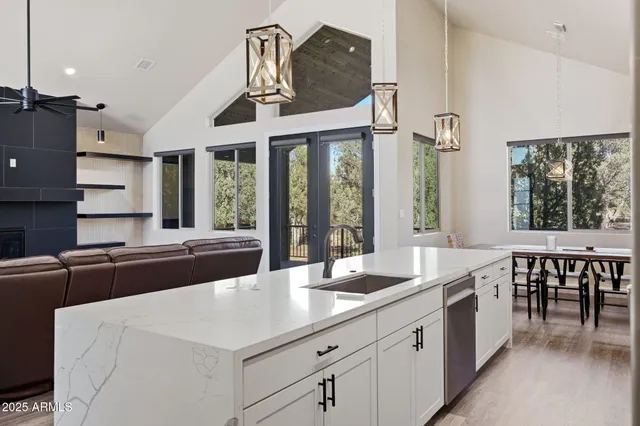 a large kitchen with stainless steel appliances a large counter top a stove a chimney a sink and dishwasher