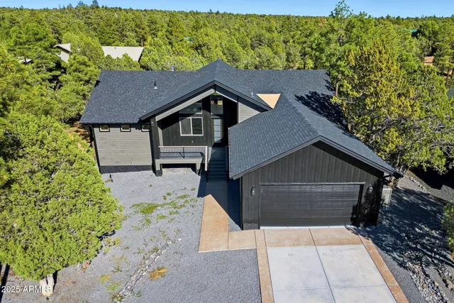 a view of house with yard and trees in the background