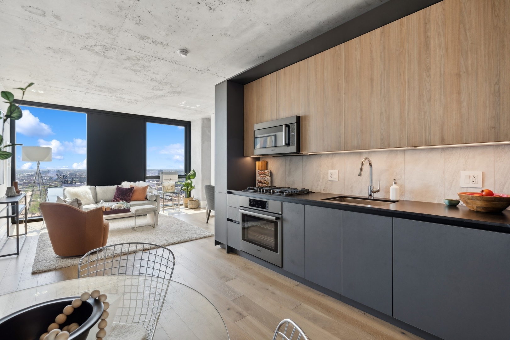234 West Polk Street, Unit 3307 Chicago, IL 60607 - Photo 7 of 31 a kitchen with a sink dishwasher a stove top oven a washer dryer and a view of living room