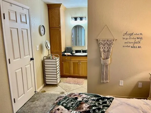 a bed sitting in a bedroom next to a cabinet