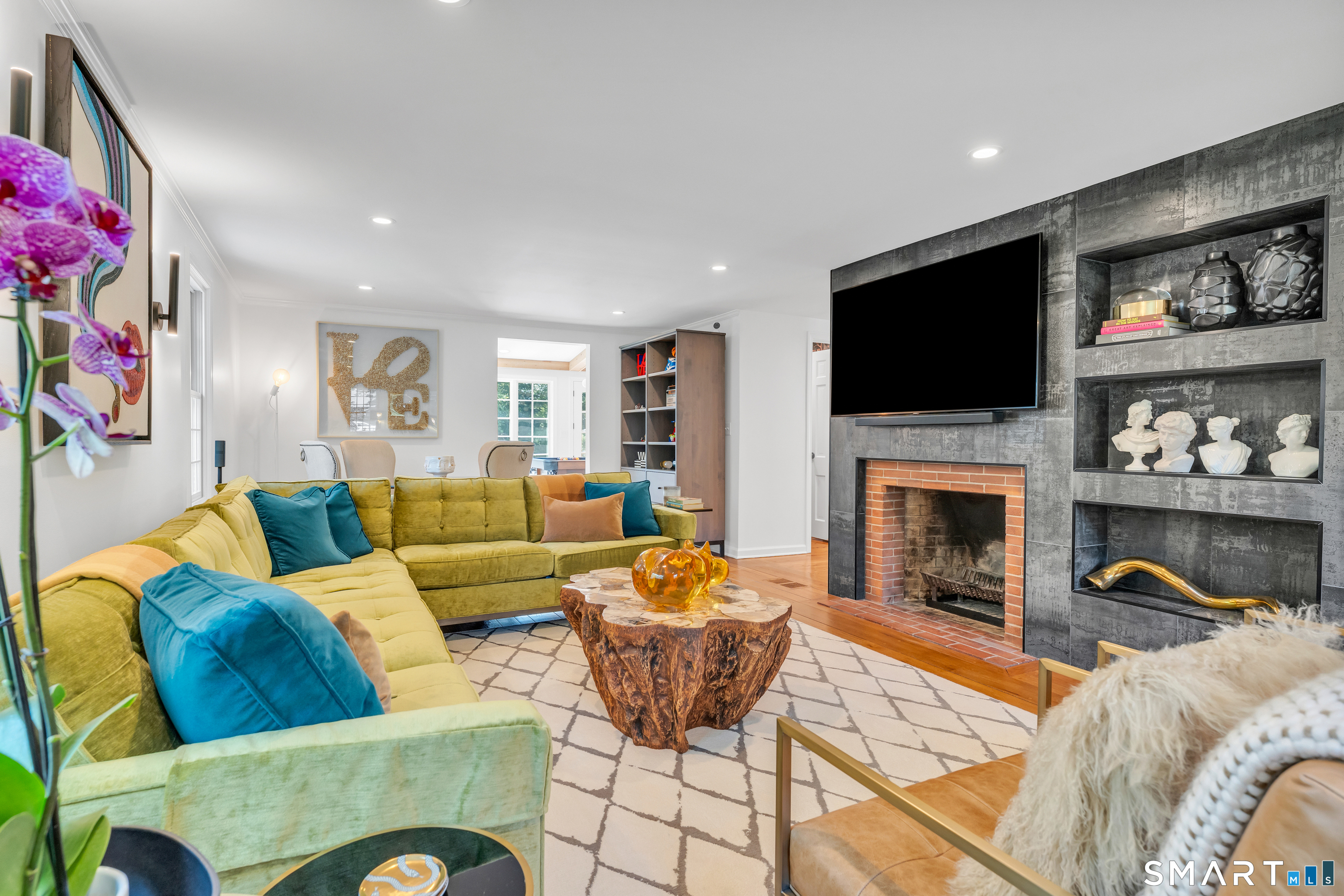 33 River Edge Farms Road Madison, CT 06443 - Photo 14 of 40 Relax in a welcoming living room centered around a wood-burning fireplace with a custom tile surround designed to resemble iron, all accented by wide-plank red oak flooring.