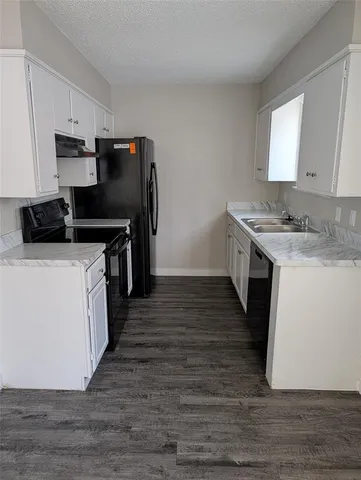 a kitchen with a stove top oven and refrigerator