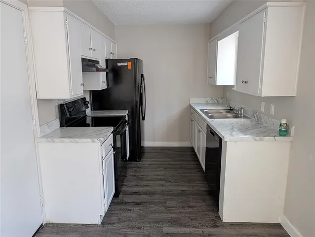 a kitchen with a sink a refrigerator and cabinets