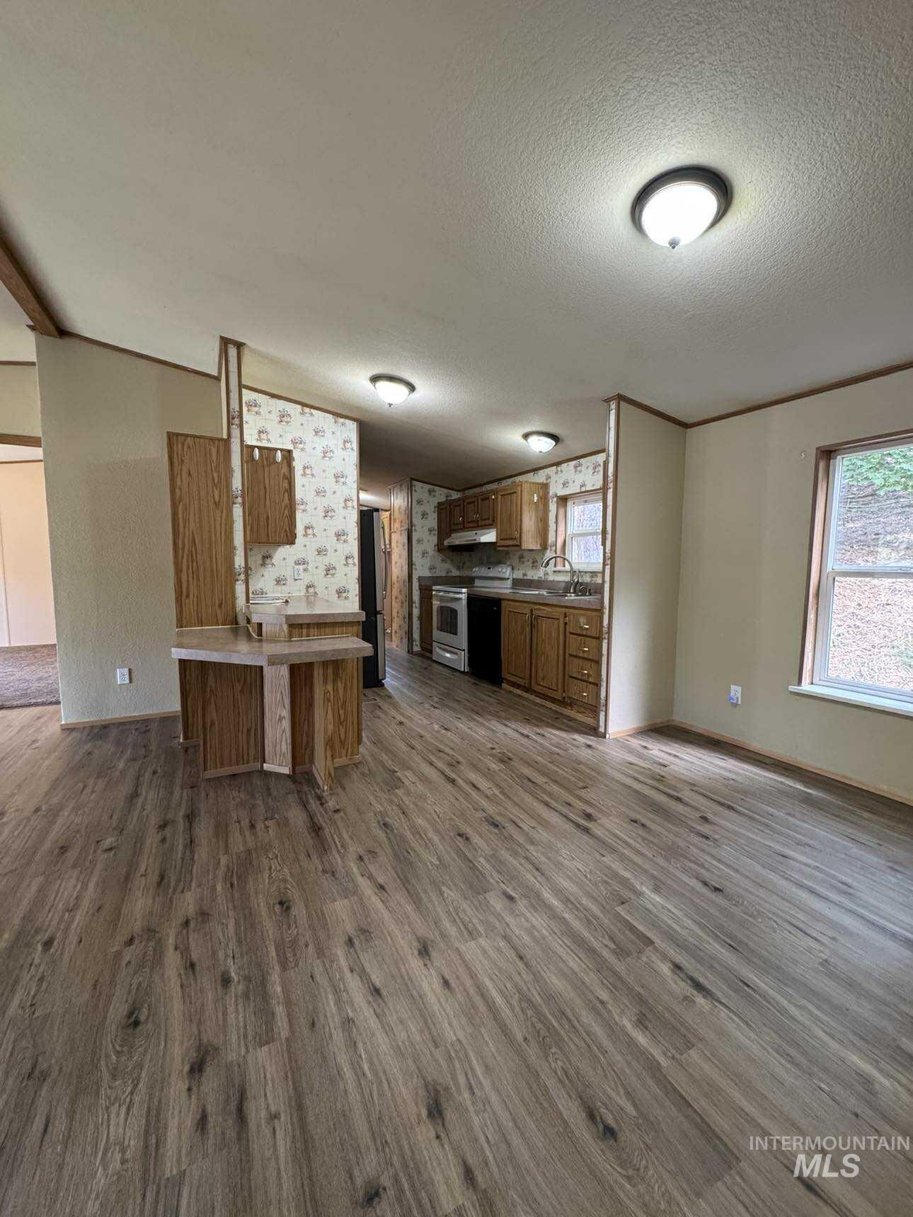 174 Elmwood Loop, Unit 7 Lenore, ID 83541 - Photo 11 of 11 Kitchen with wood finish cabinets, open floor plan, dark wood-style flooring, electric range, and a textured ceiling
