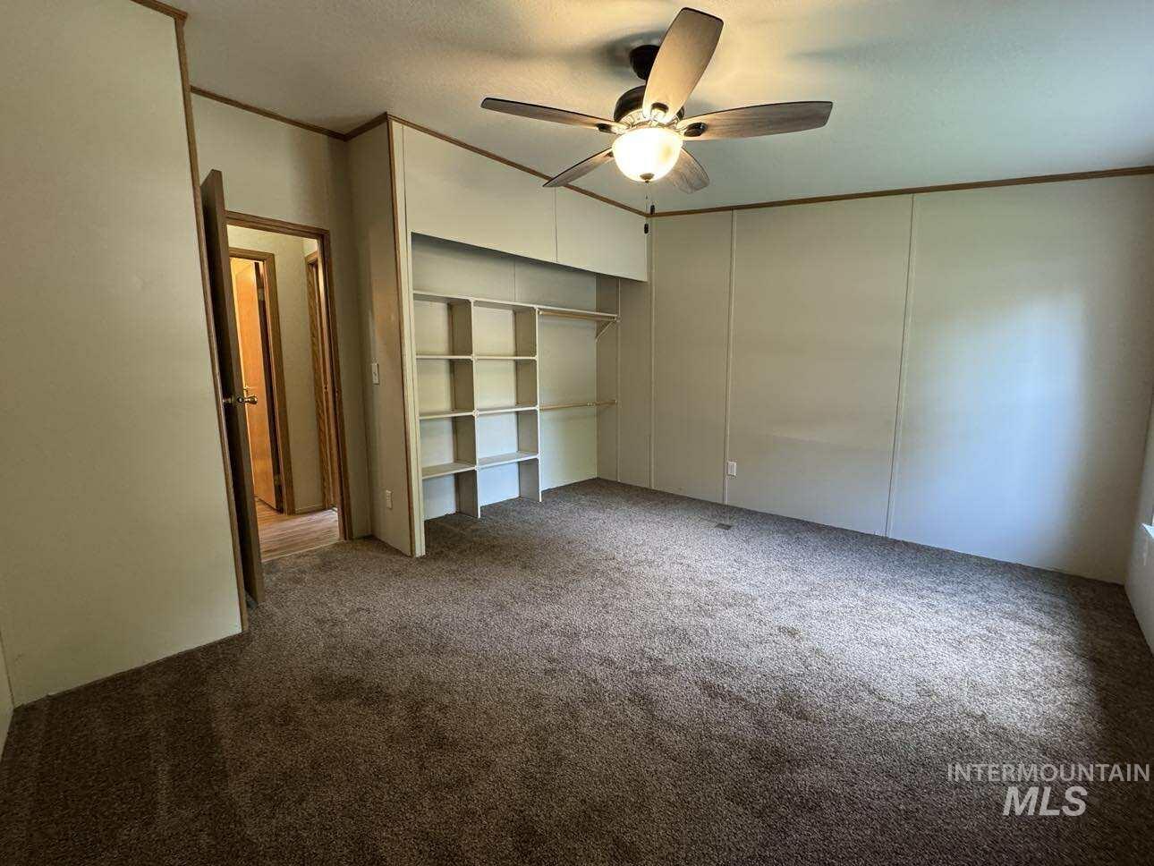 174 Elmwood Loop, Unit 7 Lenore, ID 83541 - Photo 6 of 11 Unfurnished bedroom with ornamental molding, a closet, carpet, and a ceiling fan