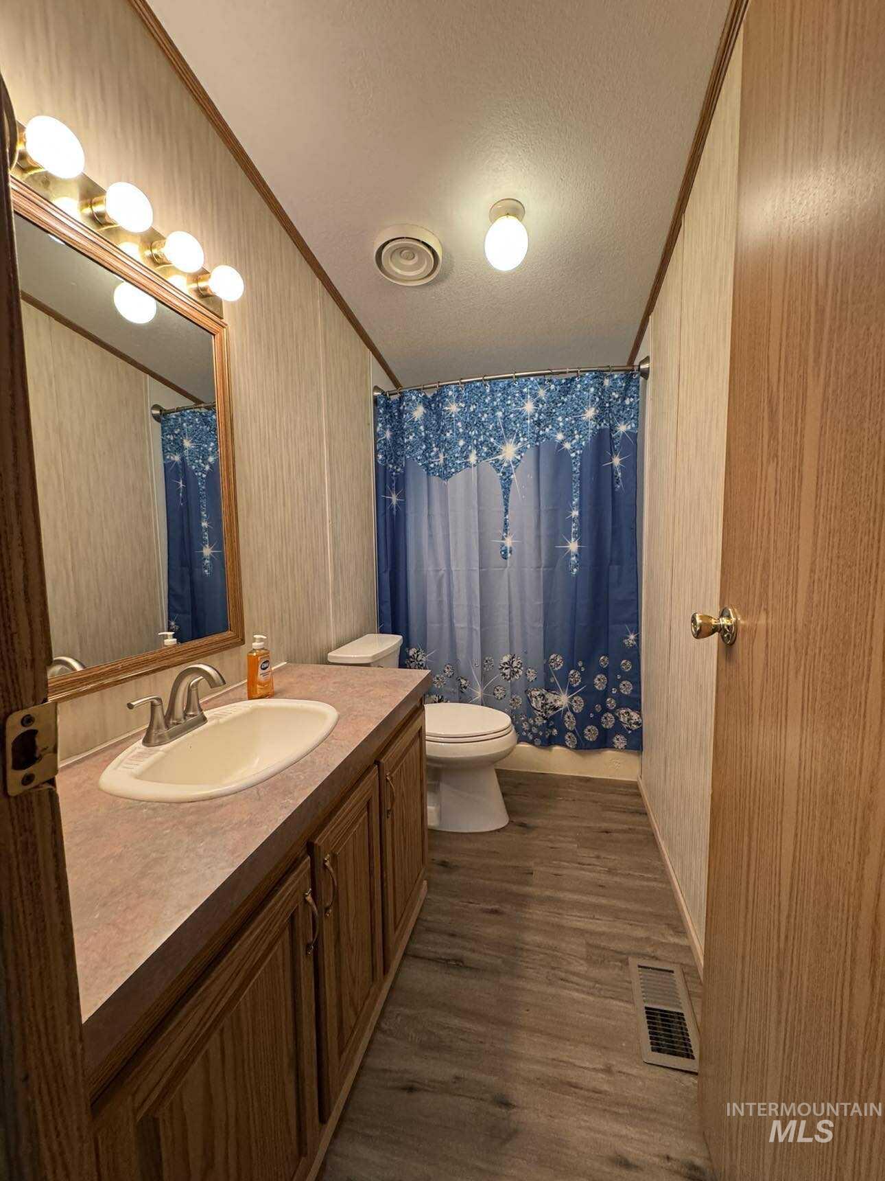 174 Elmwood Loop, Unit 7 Lenore, ID 83541 - Photo 7 of 11 Full bath with vanity, crown molding, a textured ceiling, and dark wood finished floors