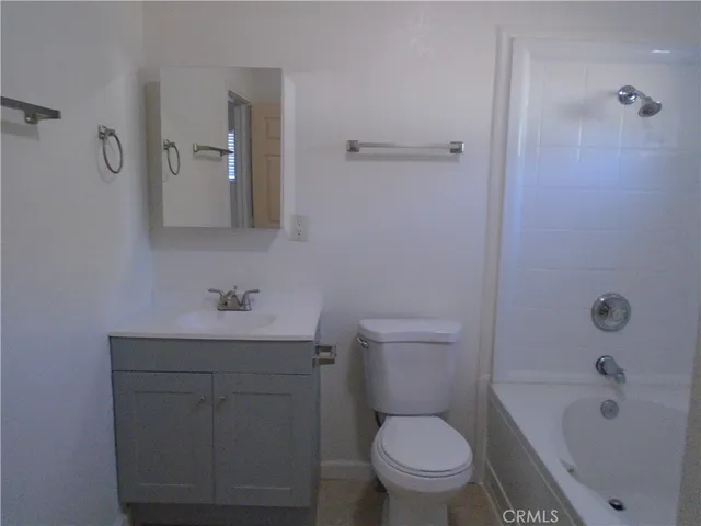 a bathroom with a toilet a sink a bath tub and mirror