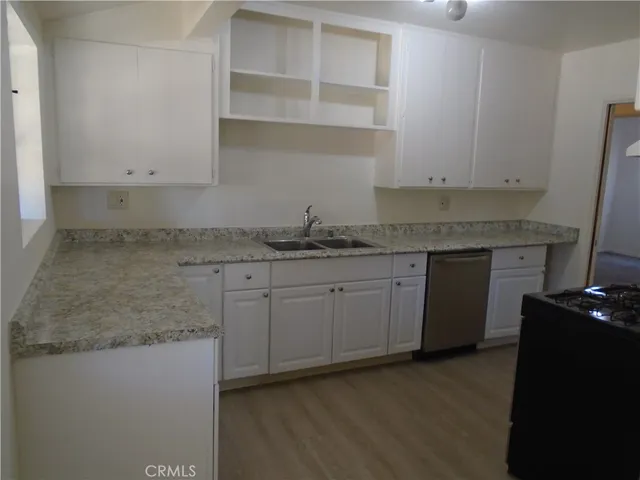 a kitchen with granite countertop cabinets stainless steel appliances and a sink