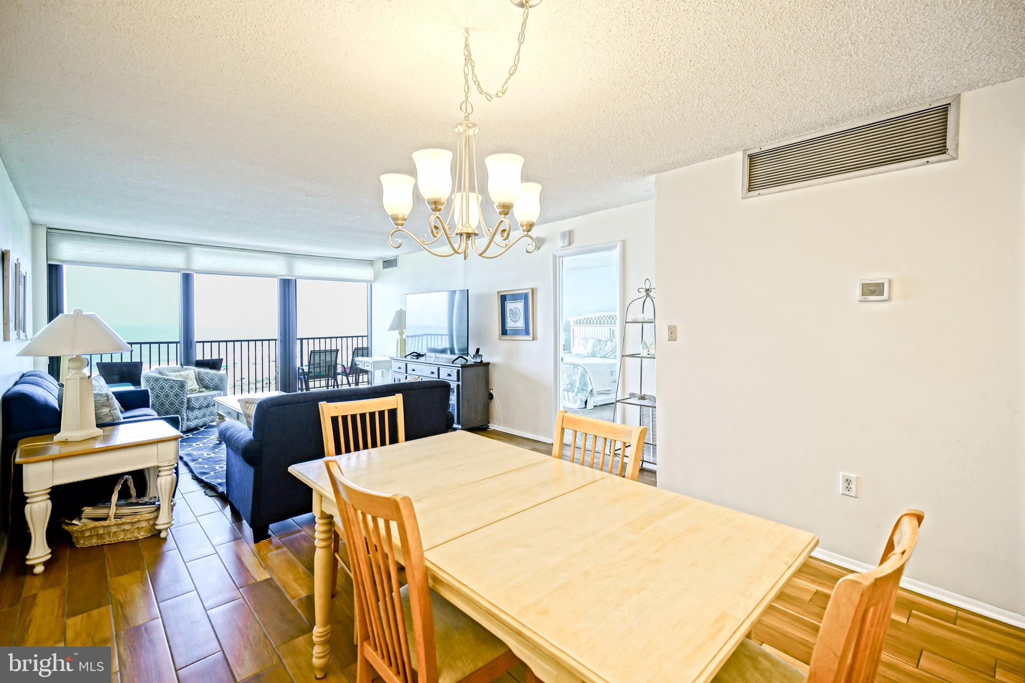 604 Dover House Road, Unit 604S Bethany Beach, DE 19930 - Photo 16 of 43 a view of a dining room with furniture a chandelier and wooden floor