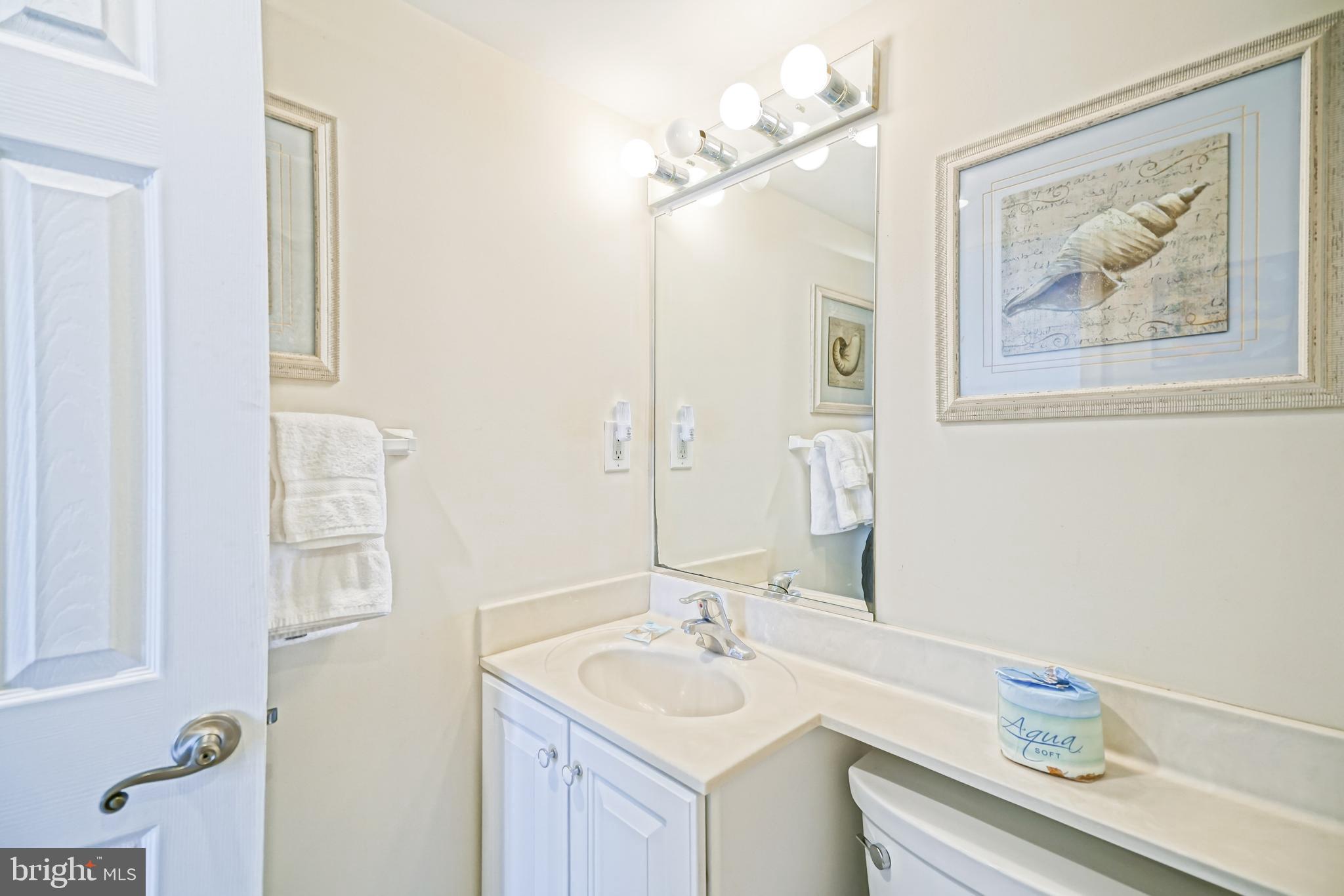 604 Dover House Road, Unit 604S Bethany Beach, DE 19930 - Photo 29 of 43 a bathroom with a sink vanity and a mirror