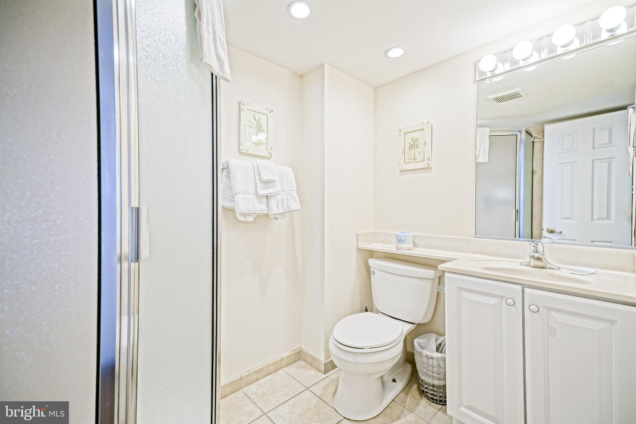 604 Dover House Road, Unit 604S Bethany Beach, DE 19930 - Photo 34 of 43 a bathroom with a toilet a sink and a mirror