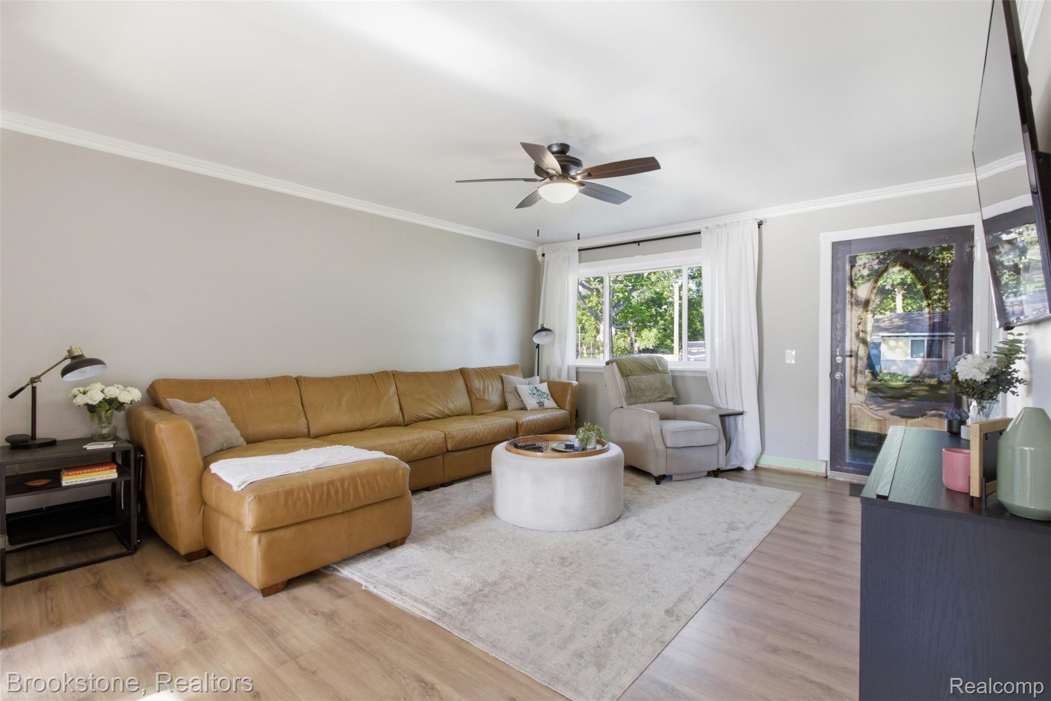 520 May Road Rochester, MI 48307 - Photo 6 of 19 Spacious living area featuring wood-finish flooring, a ceiling fan, and crown molding