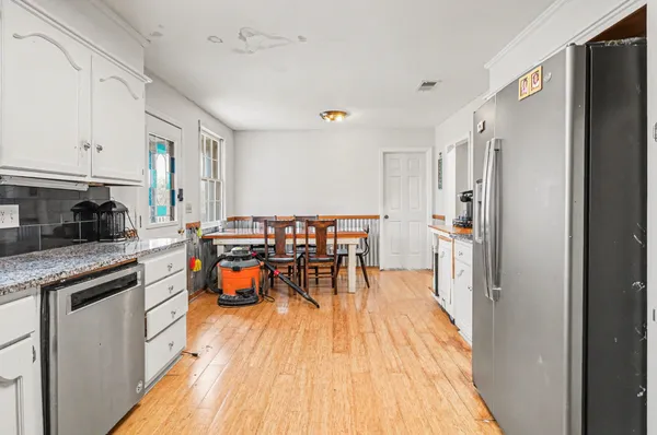 a kitchen with granite countertop white cabinets and sink
