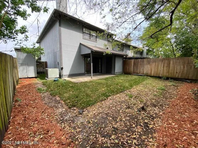 a view of a house with a yard and large tree