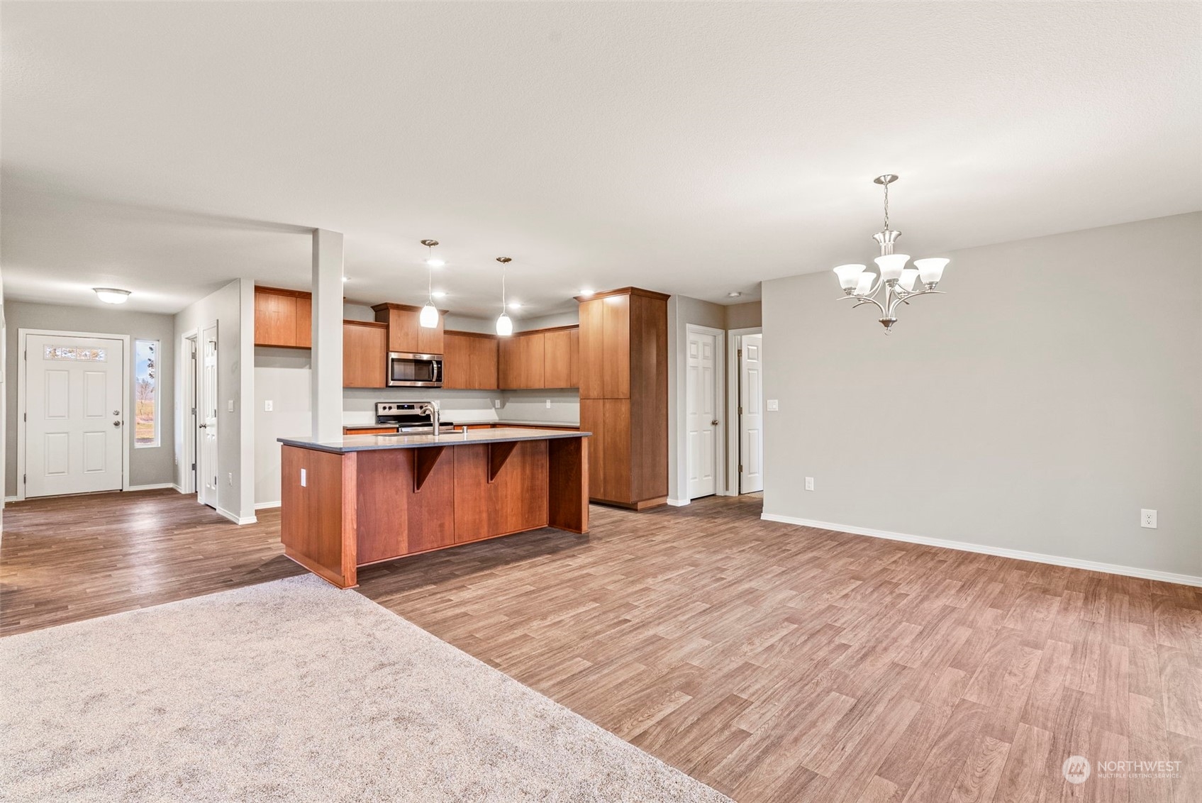 607 Tauscher Road Chehalis, WA 98532 - Photo 8 of 25 a large kitchen with kitchen island a sink dishwasher a refrigerator and a fireplace with wooden floor