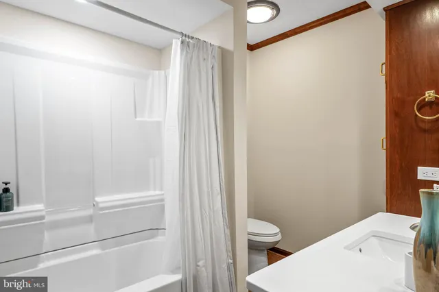 a bathroom with a granite countertop bathtub shower and a toilet