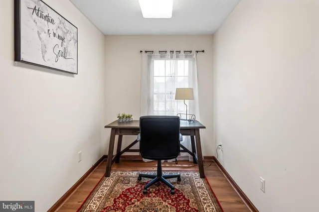 a view of a workspace with furniture and a window
