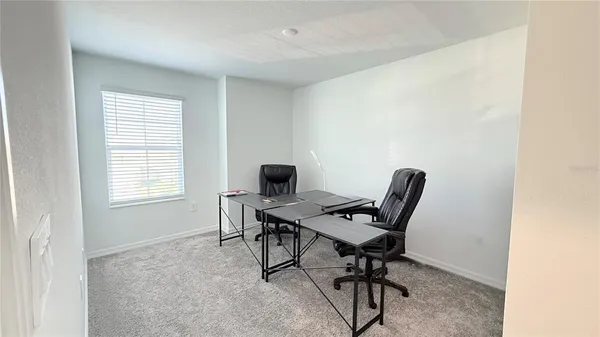 a view of a workspace with furniture and a window