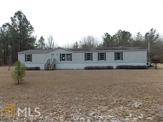 3920 Starling Road Pembroke, GA 31321 - Photo 1 of 1 a front view of house with yard and trees in the background