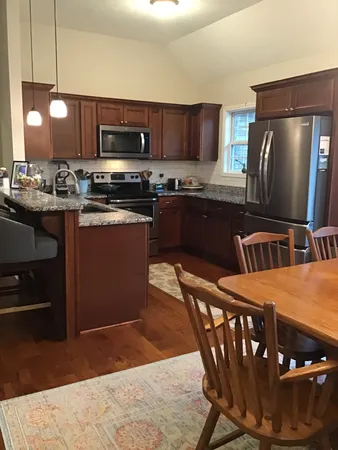 a kitchen with stainless steel appliances granite countertop a stove a sink a microwave a refrigerator and cabinets