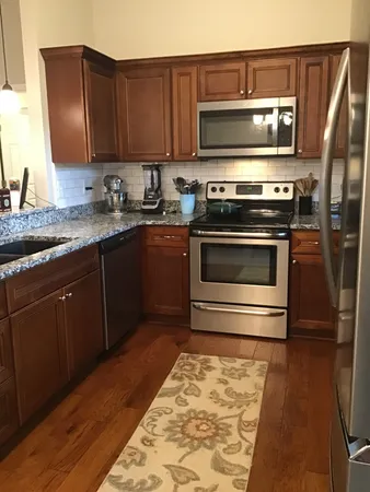 a kitchen with granite countertop a stove and a microwave