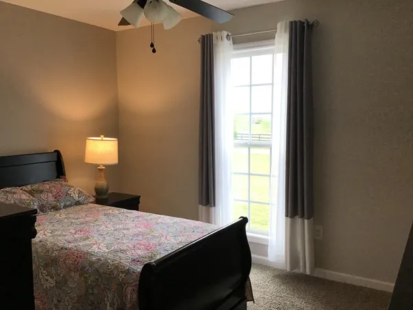 a bedroom with a bed and a lamp with window