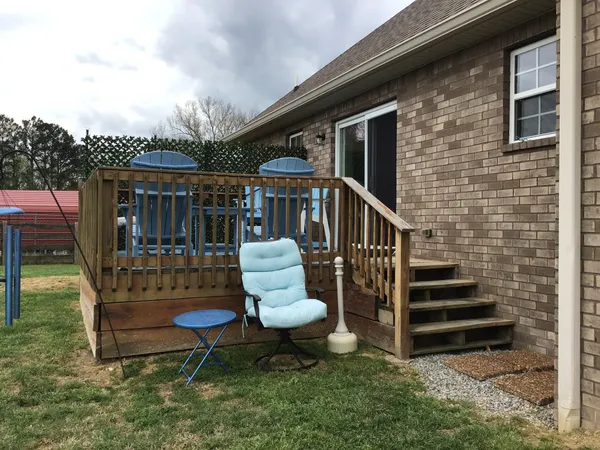 a view of a chair and table in backyard of the house