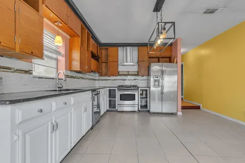 a kitchen with stainless steel appliances granite countertop a refrigerator and a sink