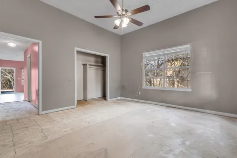 an empty room with fan and windows