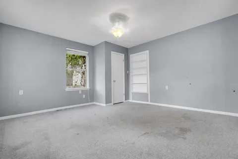 an empty room with windows and closet