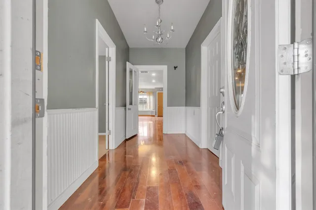 a view of a hallway with wooden floor and cabinet
