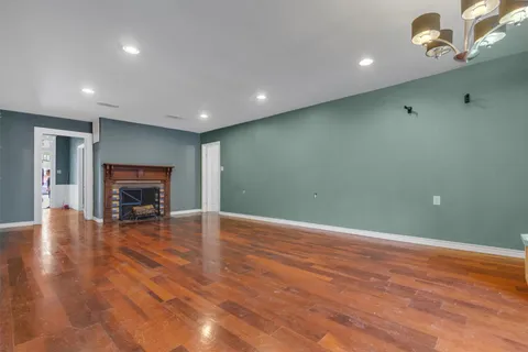 a view of empty room with wooden floor and fireplace